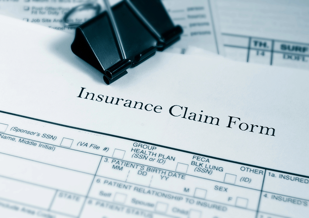 Paperwork for filing an insurance claim on table